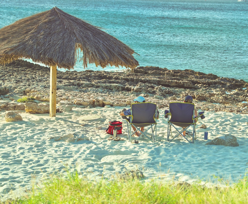 people sitting on beach chairs near beach during daytime