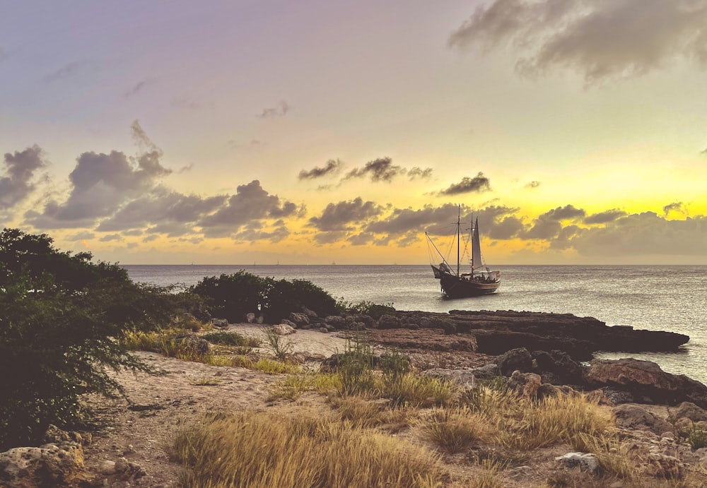 black ship on sea under cloudy sky during daytime