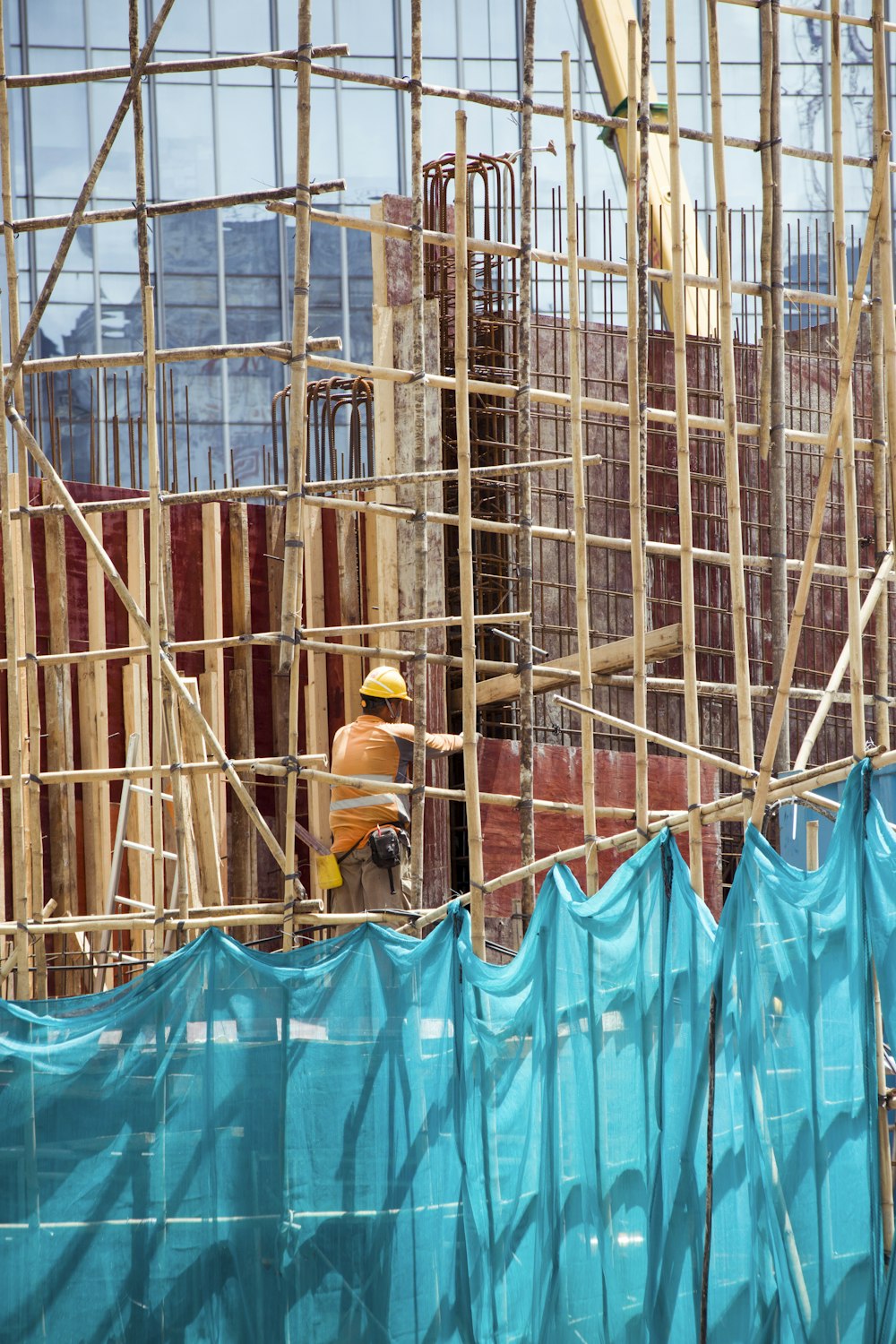 man in yellow hard hat and yellow hard hat sitting on blue plastic chair