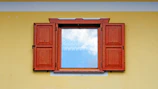 Freshly painted wooden window frames on a classic Utrecht home under a bright sky.