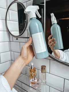 person holding white plastic bottle