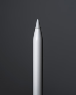 A close-up view of a sleek, metallic stylus pen standing upright against a dark grey background. The pen has a smooth, reflective surface with a pointed tip, and the lighting creates subtle highlights along its body.