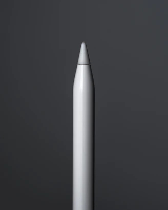 Close-up of a sleek, modern pencil resting on a clean white desk with soft natural light.