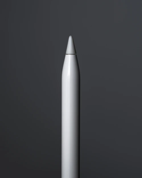 Close-up of a sleek, modern pencil resting on a clean white desk with soft natural light.