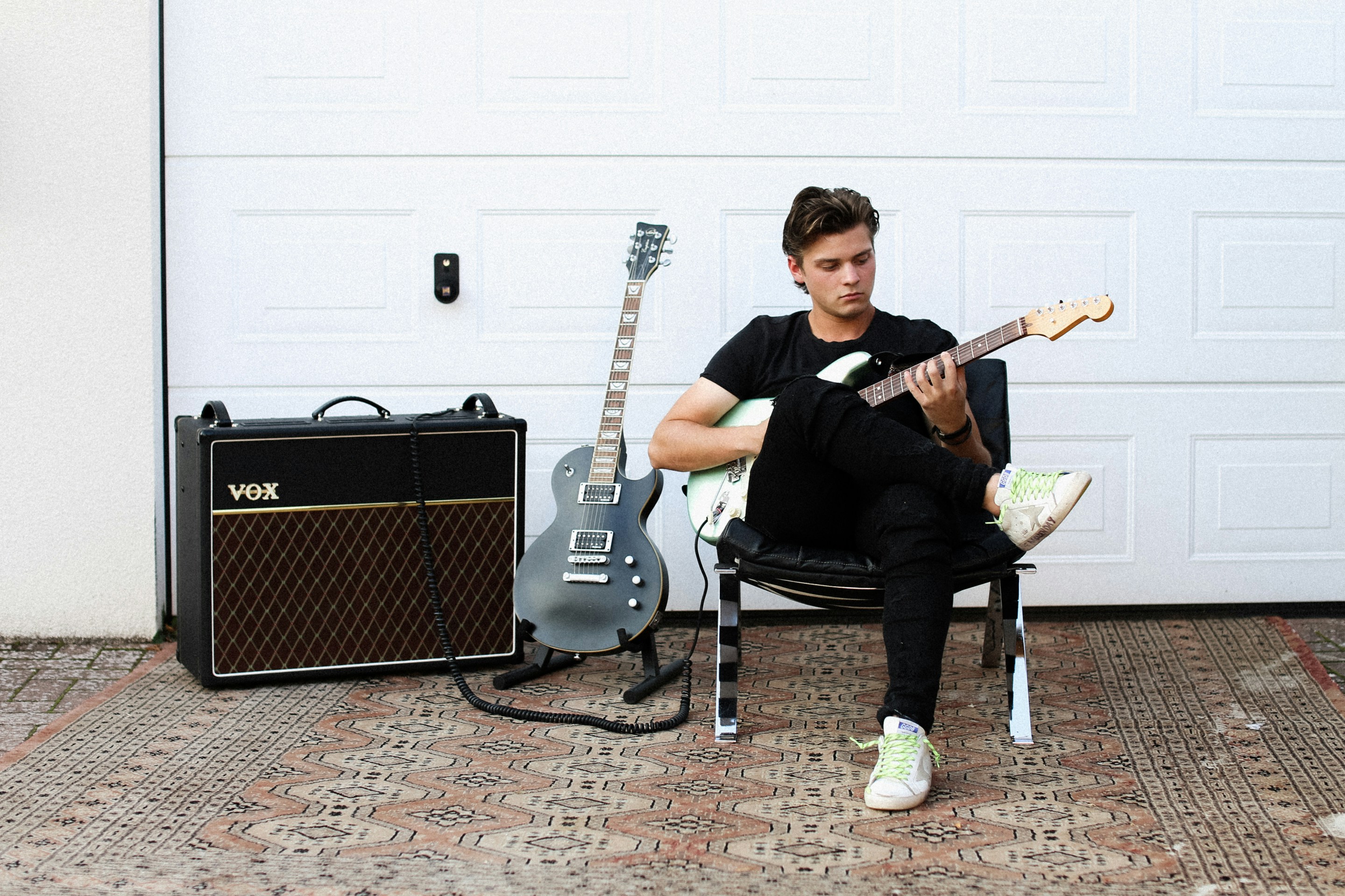 man in black crew neck t-shirt playing guitar
