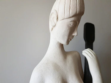 A minimalist sculpture made of smooth white marble with elegant curves.