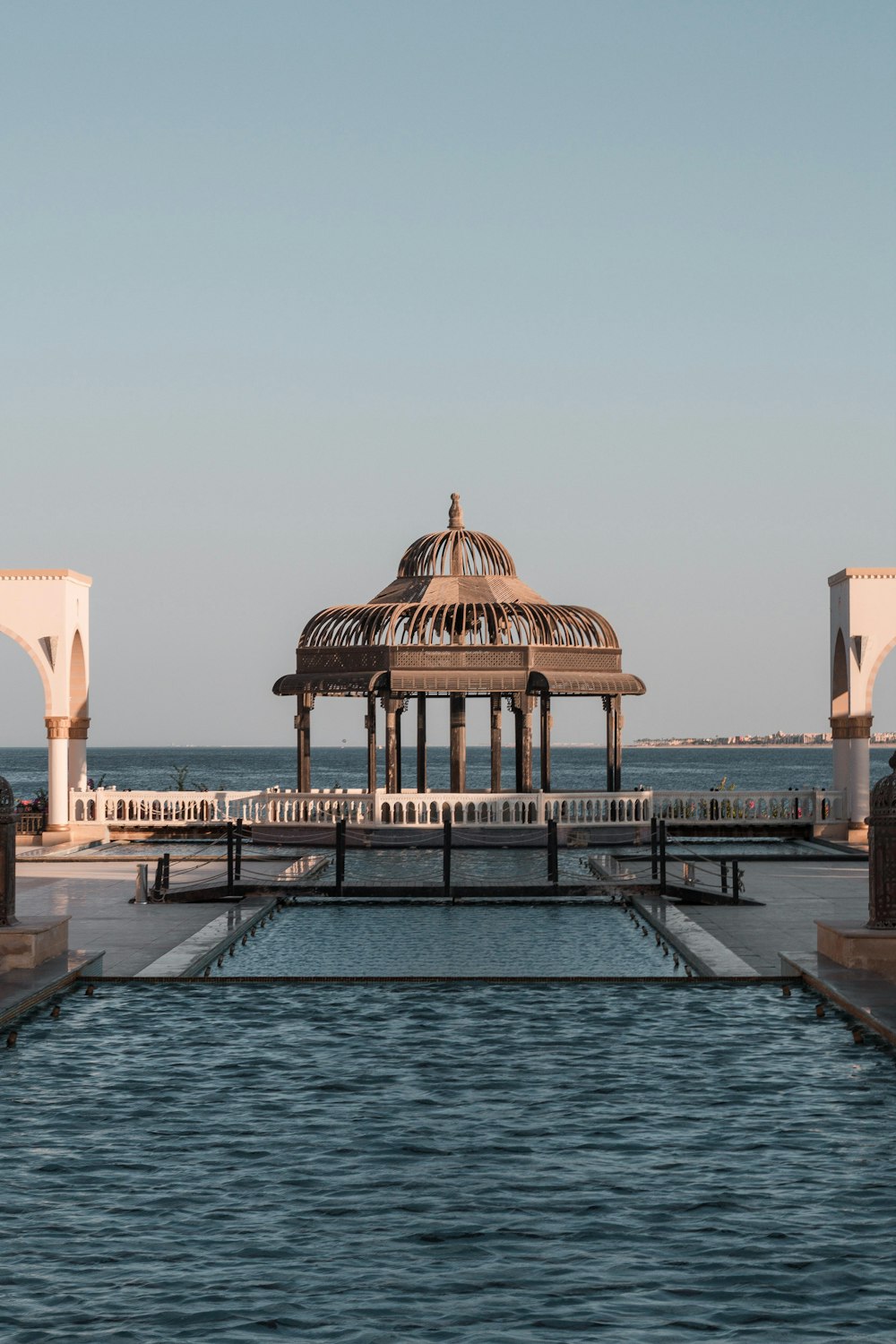 edificio in cemento marrone vicino allo specchio d'acqua durante il giorno