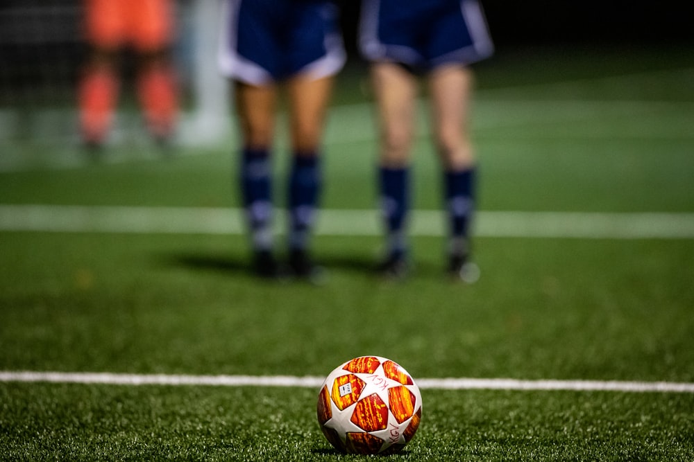 soccer player in blue and white jersey shirt and shorts standing on green grass field