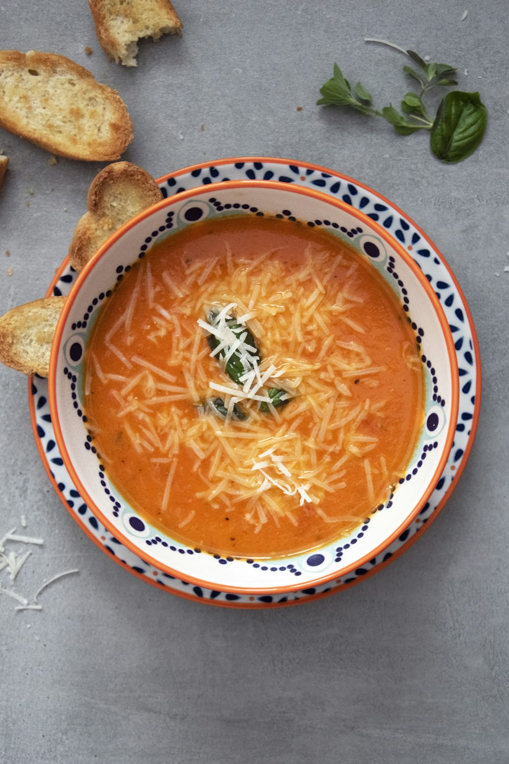 orange soup on white and blue ceramic bowl