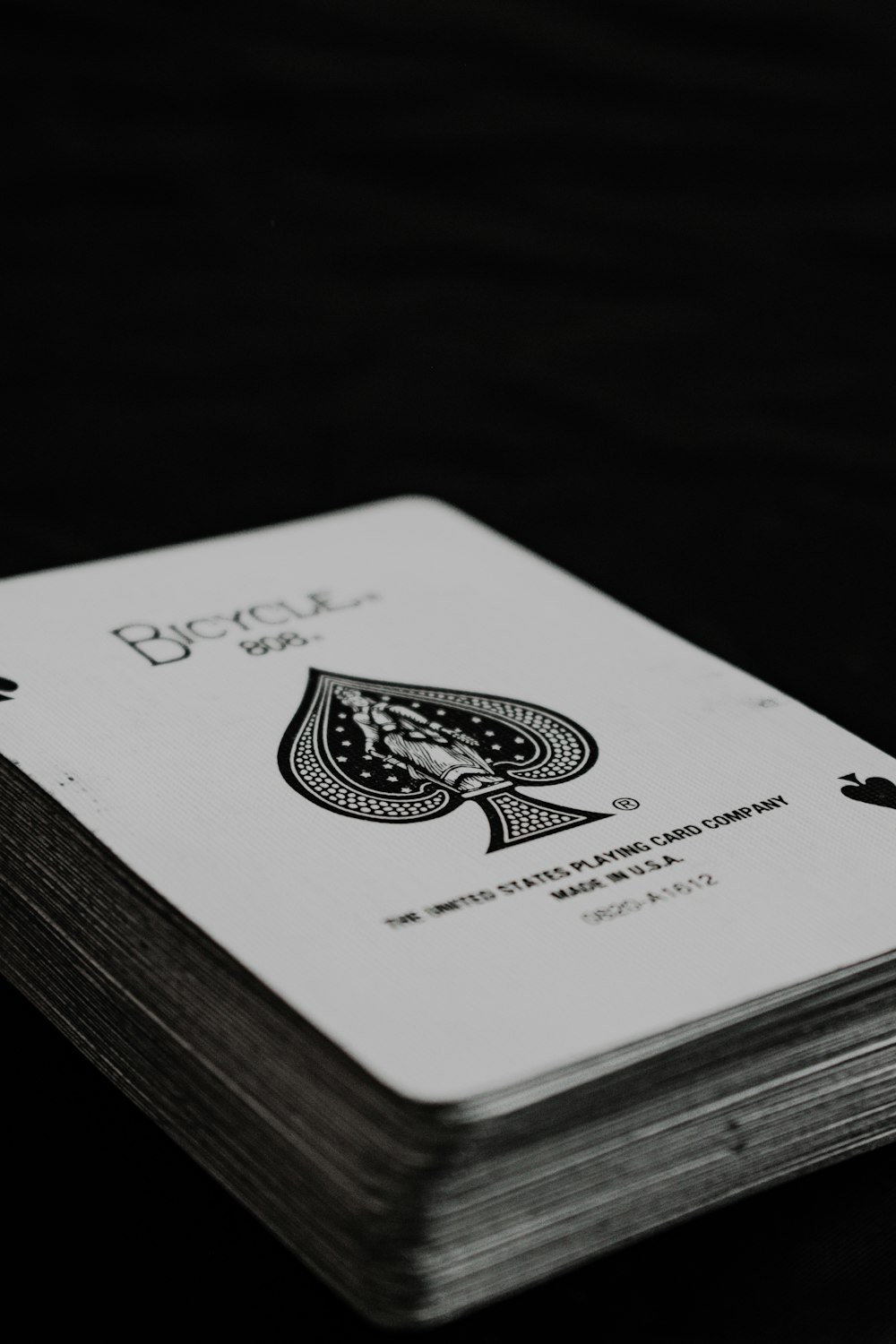 white and black playing card on black table