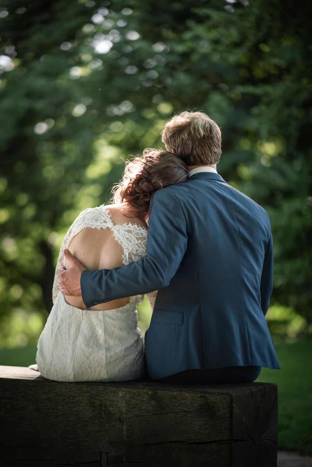 Mann im blauen Anzug und Frau im weißen Kleid küssen sich