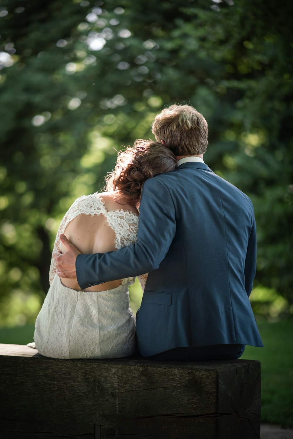 man in blue suit and woman in white dress kissing