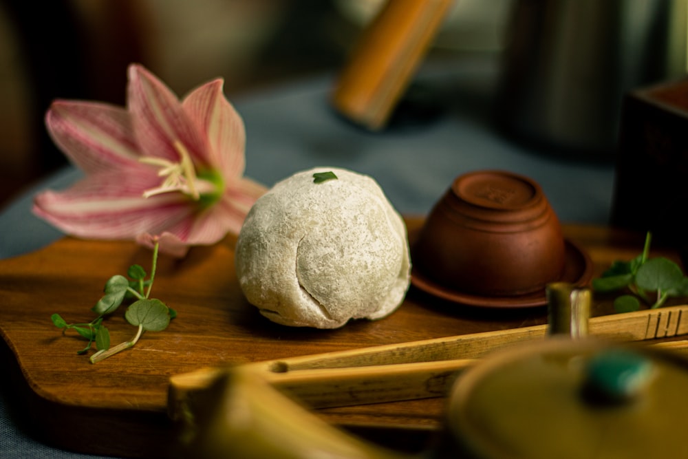 piedra blanca y rosa sobre tabla de cortar de madera marrón