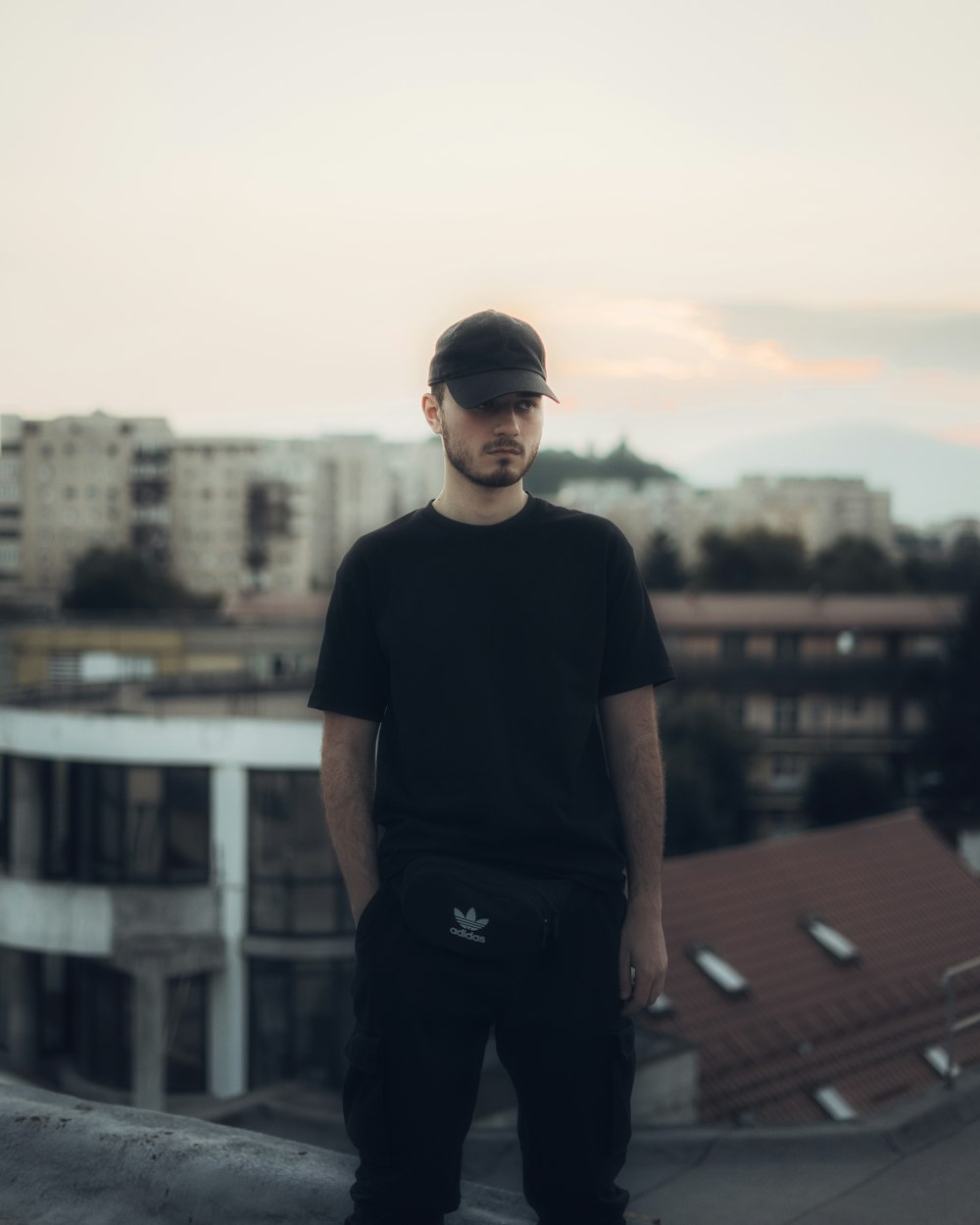 man in black crew neck t-shirt standing on building during daytime