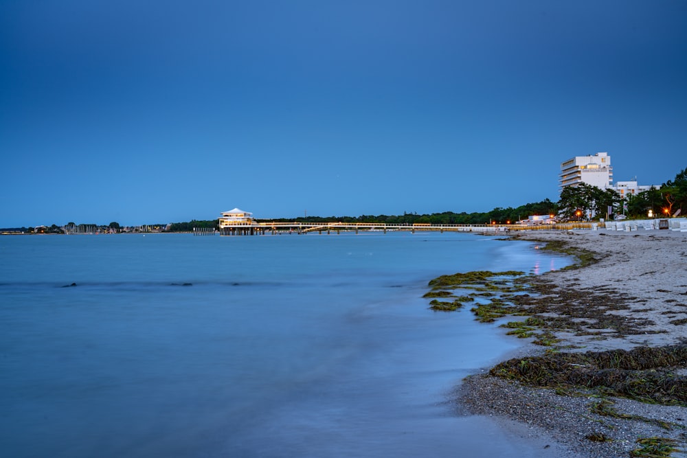 white and brown concrete building near body of water under blue sky during daytime