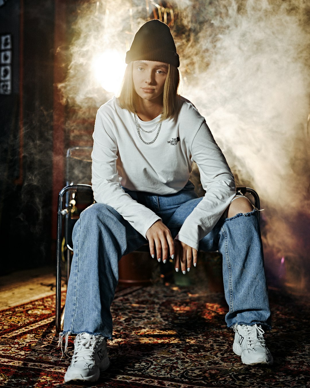 man in white zip up hoodie and blue denim jeans sitting on chair