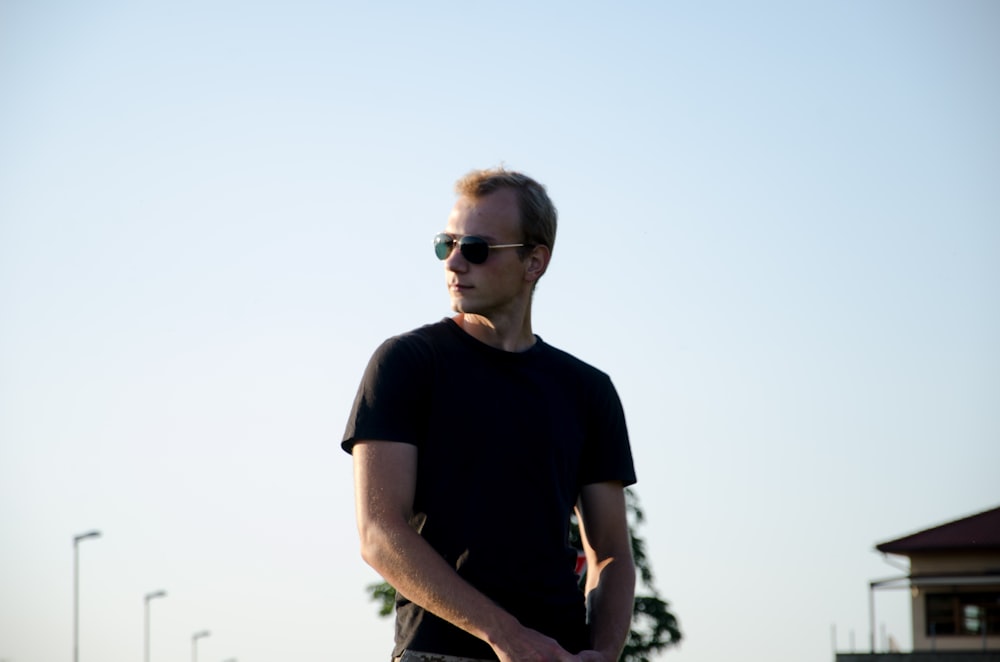 man in black crew neck t-shirt wearing sunglasses