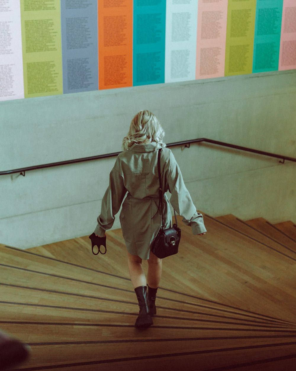 woman in green jacket and black pants walking on brown wooden floor