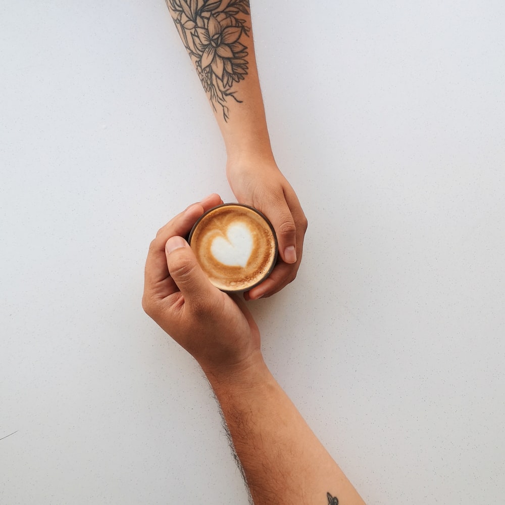 person holding white ceramic mug