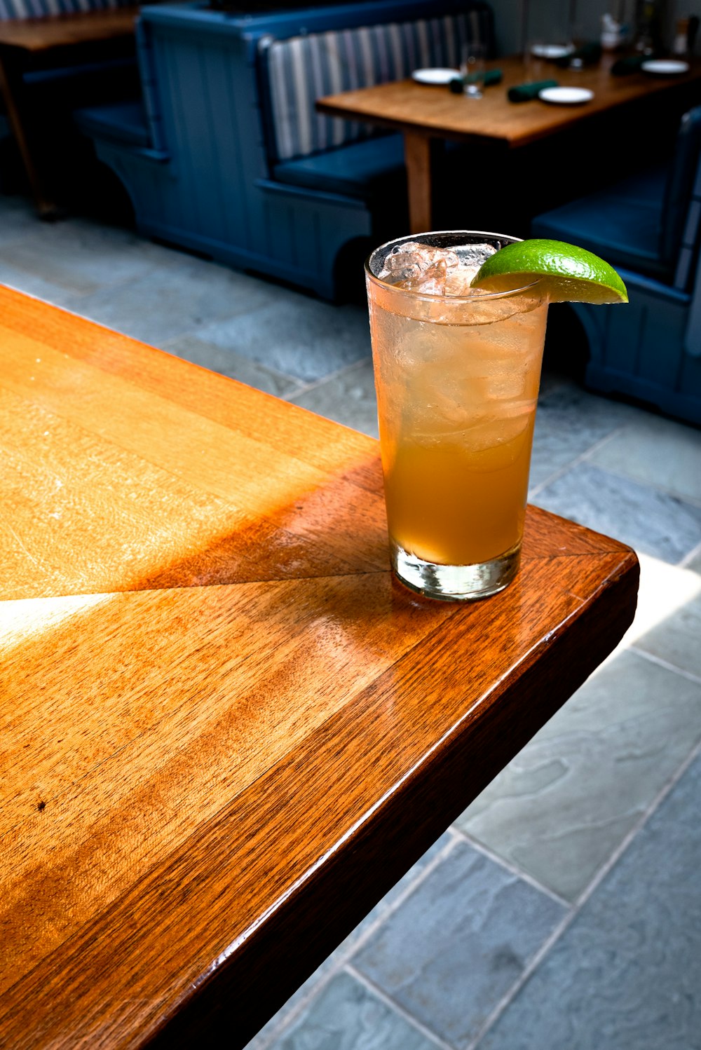 clear drinking glass with yellow liquid on brown wooden table