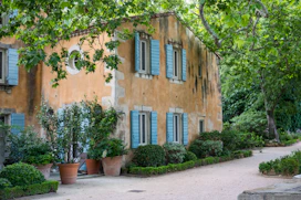 brown concrete building near green trees during daytime