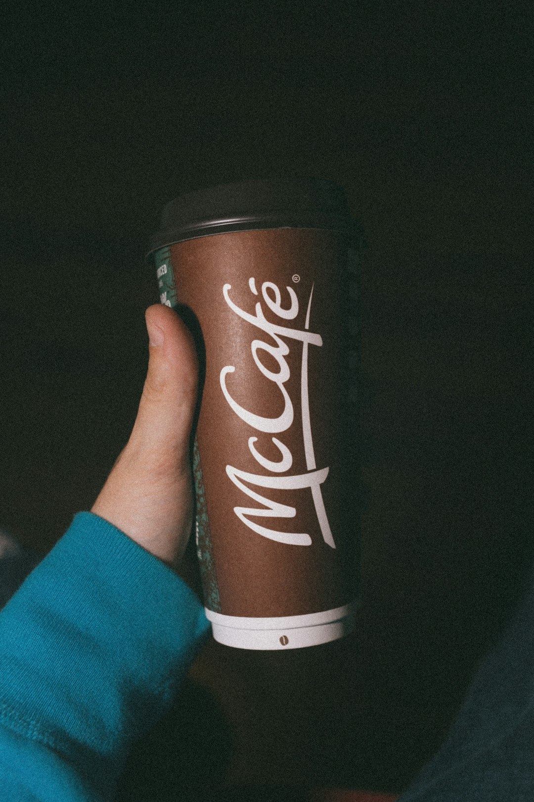 person holding brown and white coca cola cup