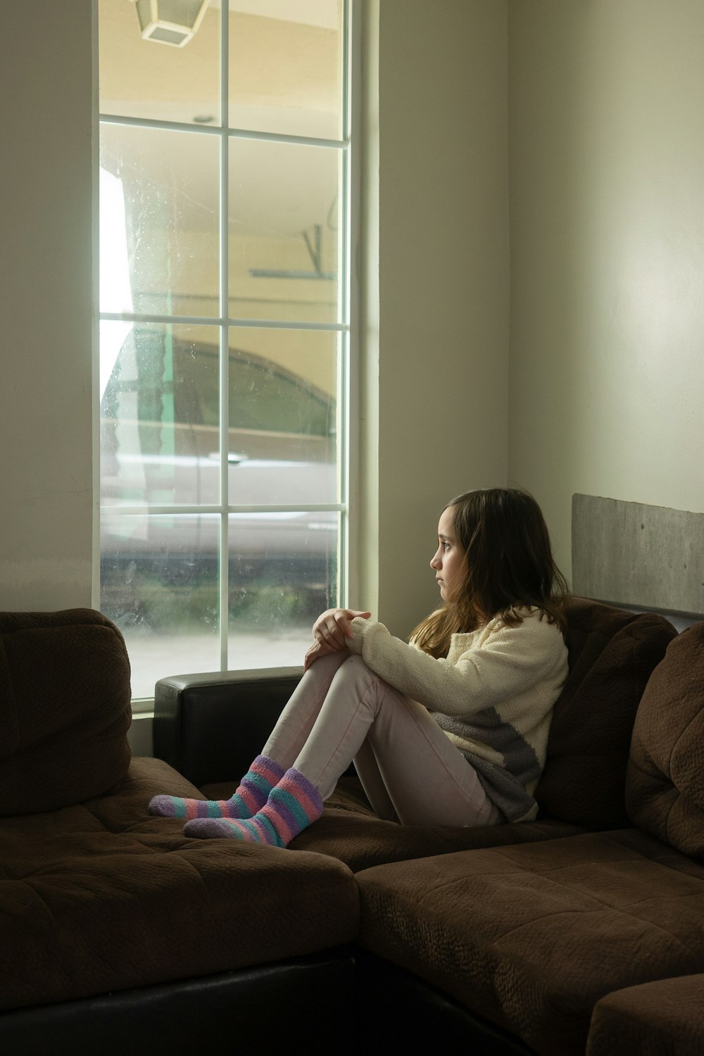 woman in white long sleeve shirt sitting on black couch