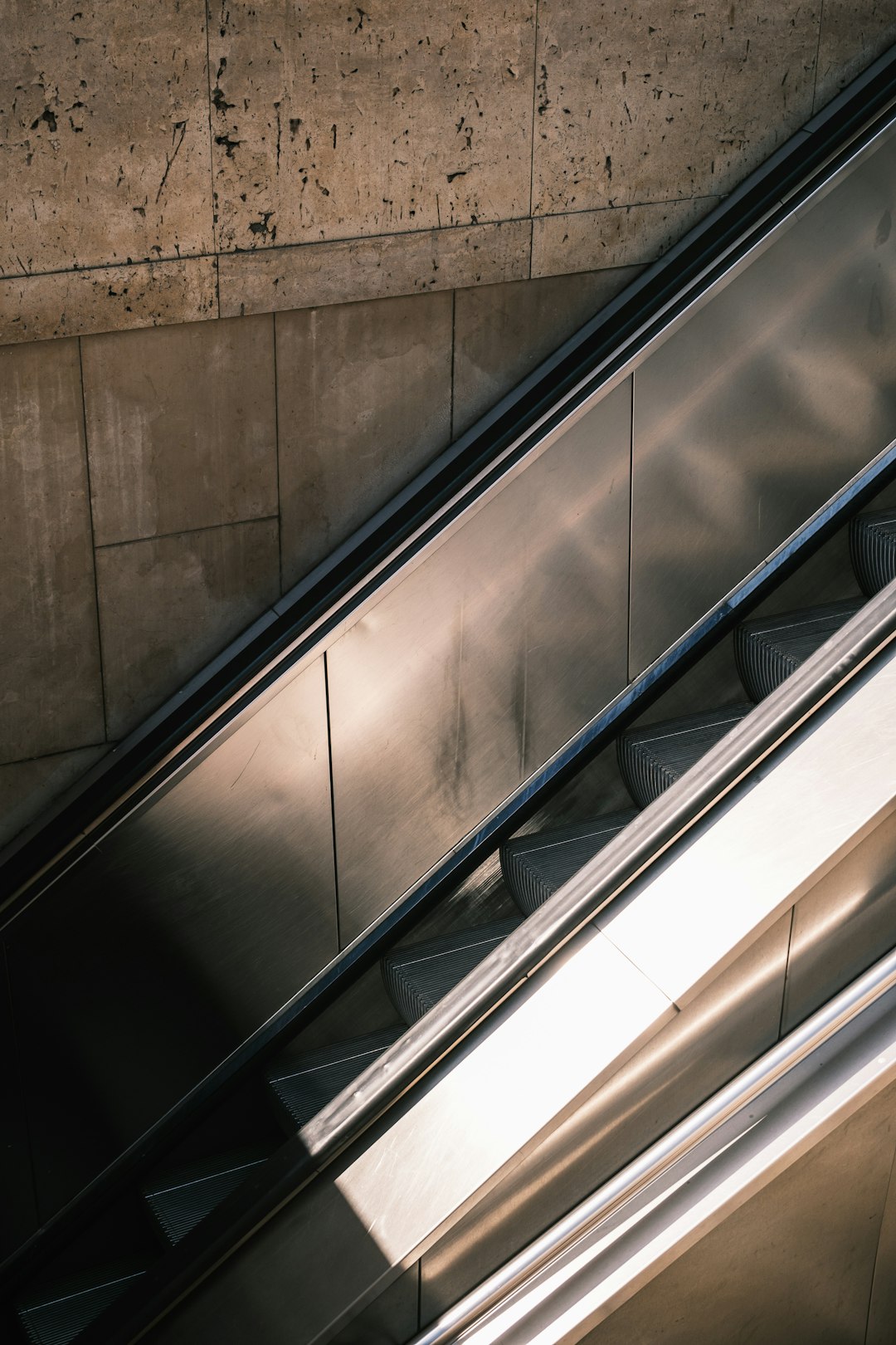 stainless steel railings beside brown concrete wall