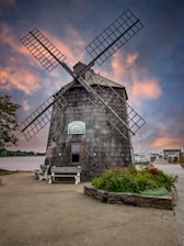 gray and black windmill near green plants under blue sky during daytime