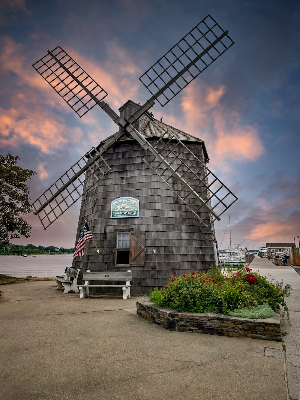 gray and black windmill near green plants under blue sky during daytime