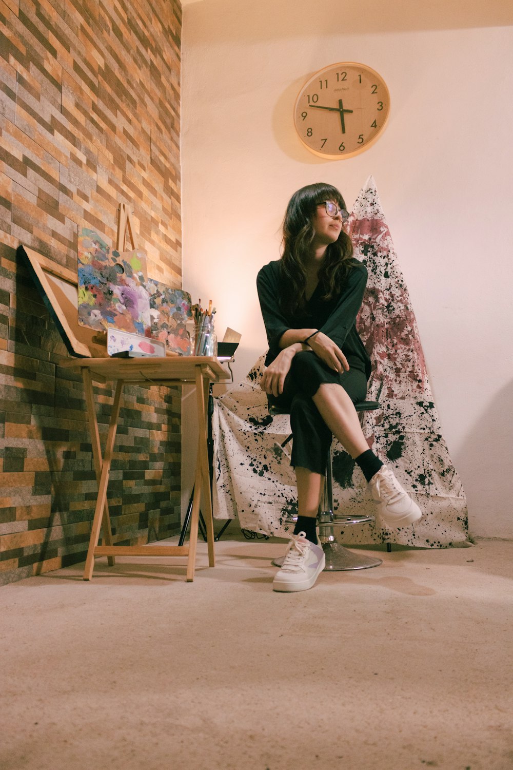 woman in black long sleeve shirt sitting on brown wooden chair