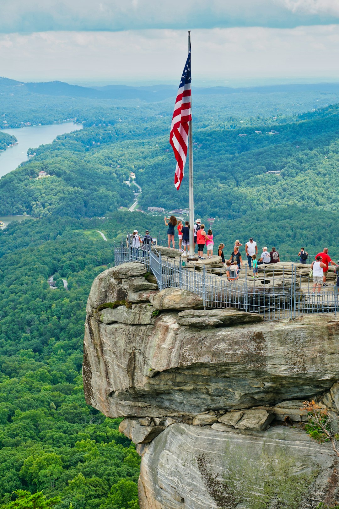 people on top of rock formation near body of water during daytime