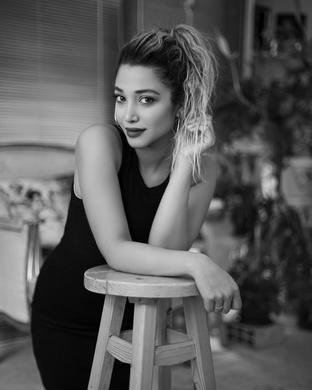 grayscale photo of woman in black tank top sitting on chair