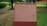 A brick plaque with detailed text about the historical site of Nalanda is situated in a lush green setting. The text provides an extensive historical background of Nalanda, an ancient center of learning. Trees and grass surround the plaque, suggesting a park or maintained garden setting.
