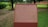 A brick plaque with detailed text about the historical site of Nalanda is situated in a lush green setting. The text provides an extensive historical background of Nalanda, an ancient center of learning. Trees and grass surround the plaque, suggesting a park or maintained garden setting.