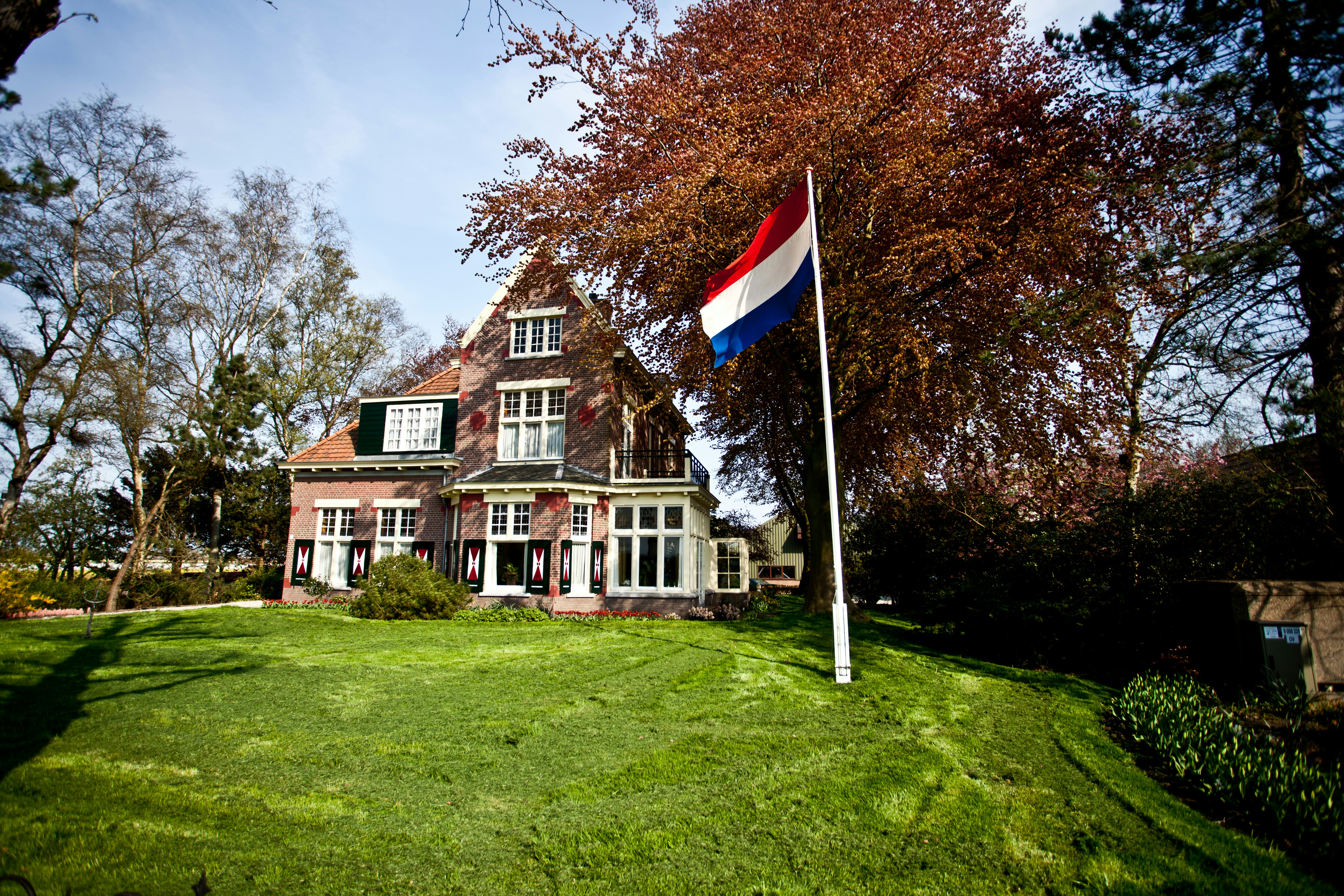 brown and white concrete house with flag of america on top