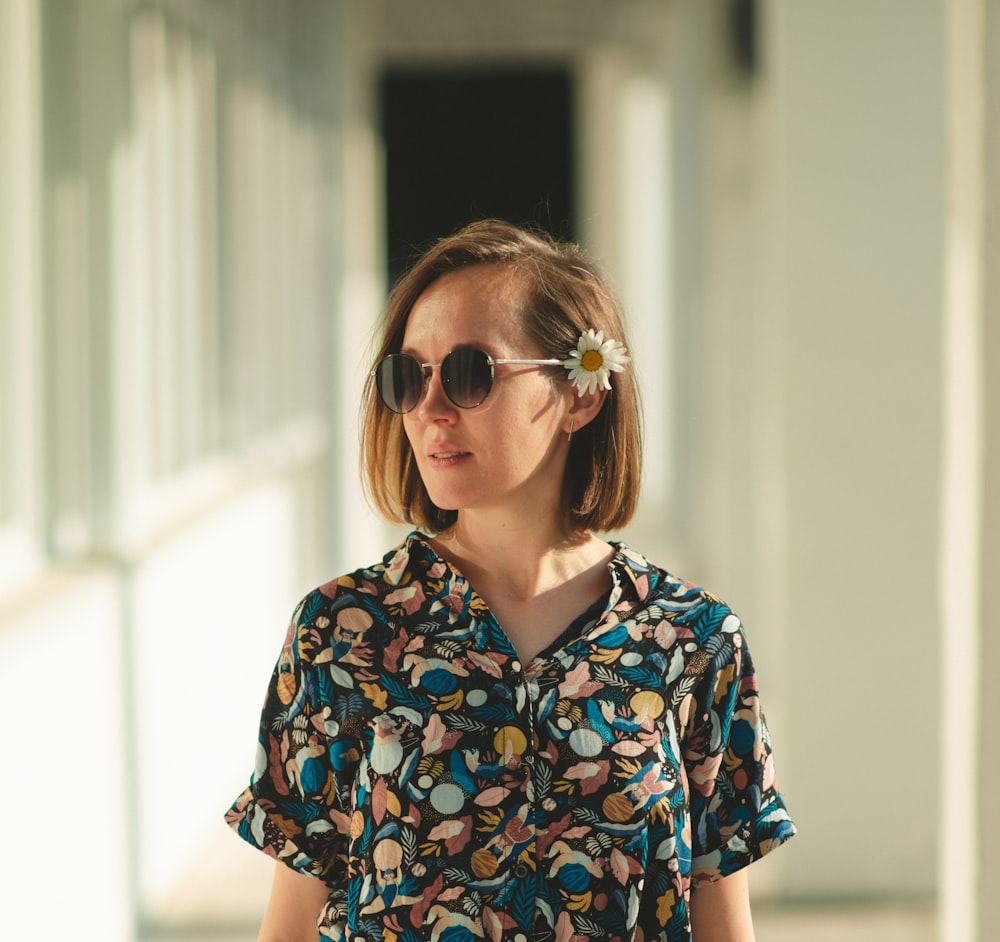 woman in blue and white floral button up shirt wearing brown sunglasses