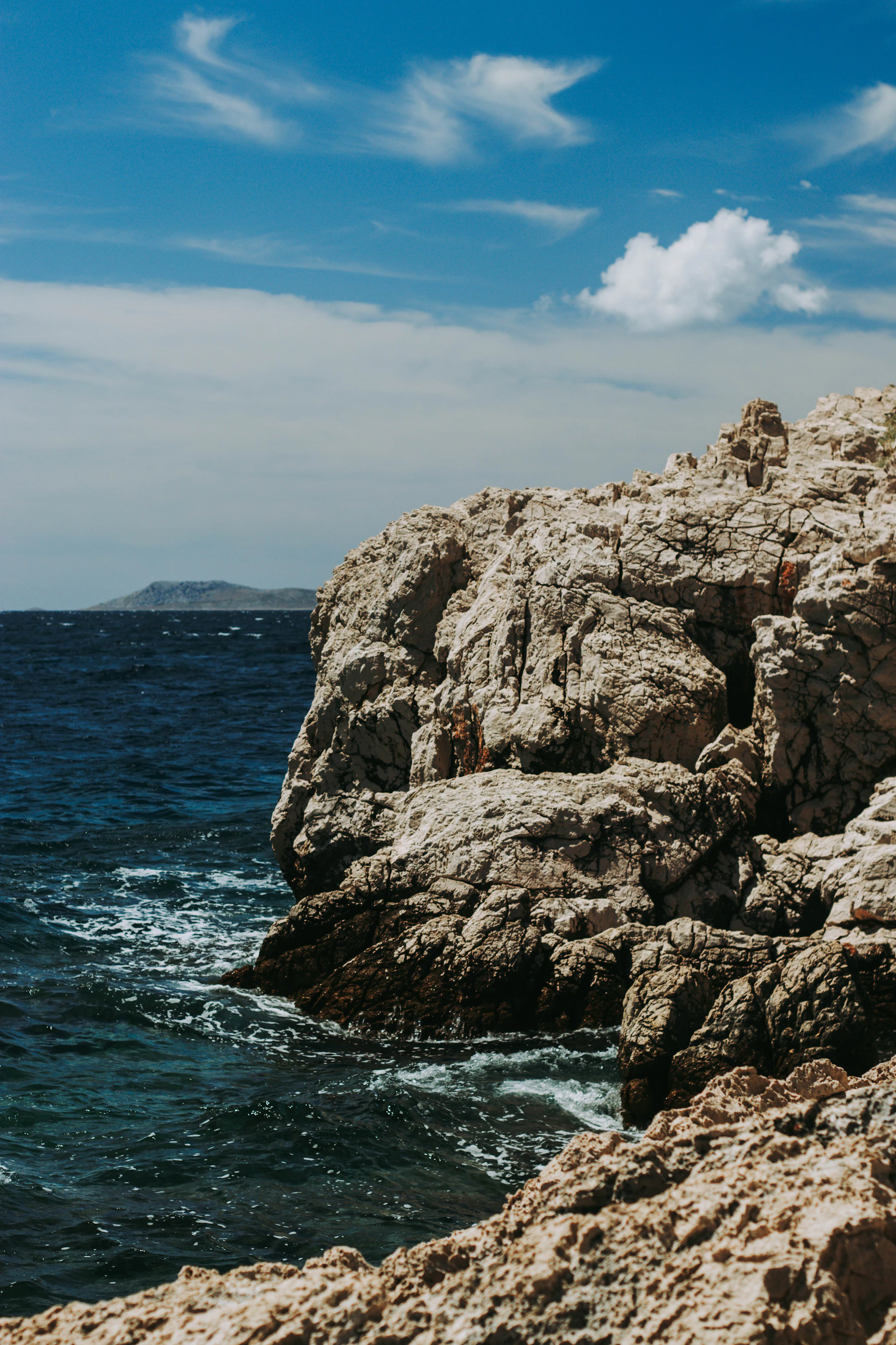 A rocky coastal formation rises from clear water.