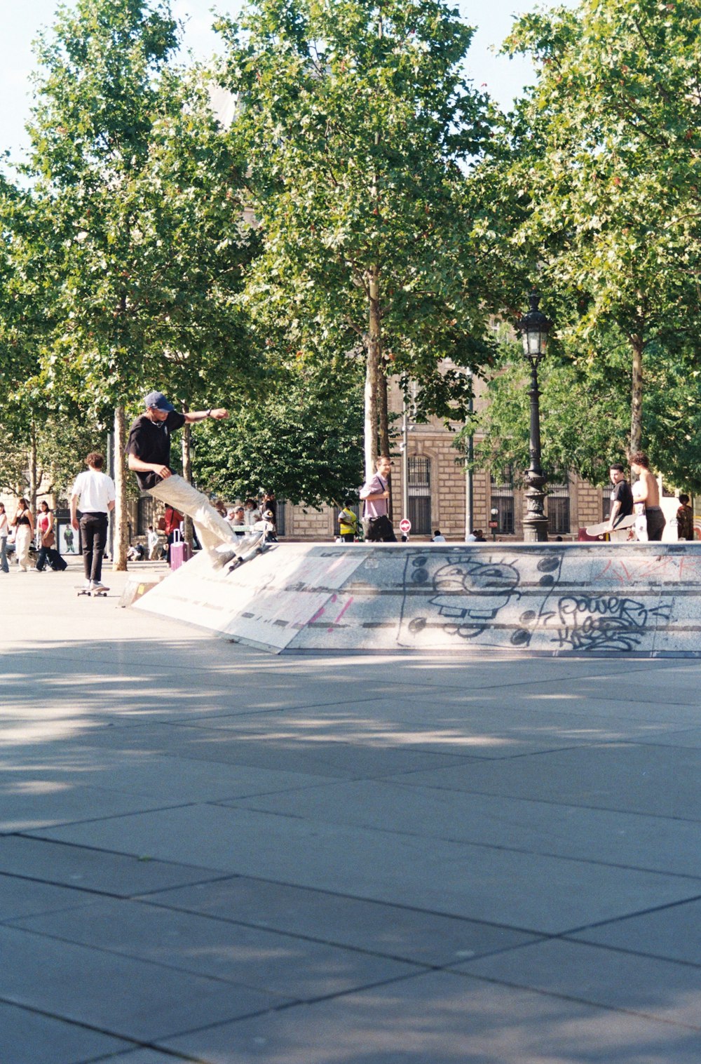 man in black t-shirt and white pants playing skateboard during daytime