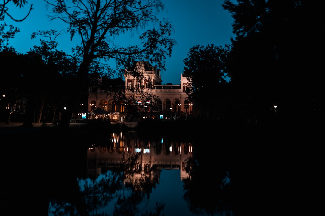 brown concrete building near body of water during night time