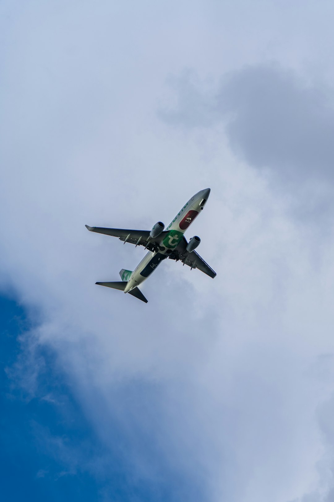 green and white airplane flying in the sky