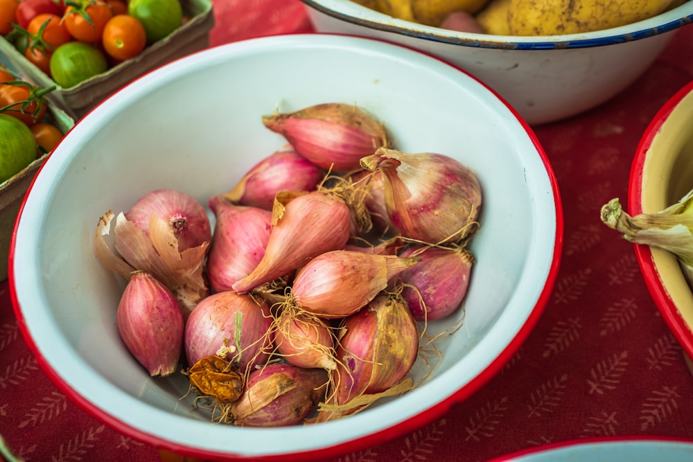 rote und braune Zwiebel auf weißer Keramikschale