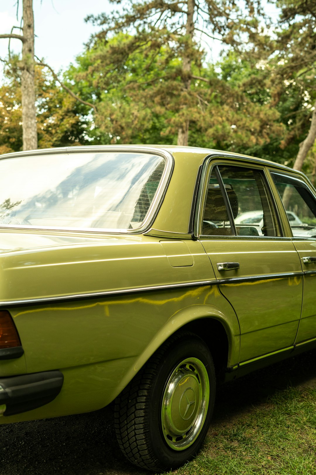 yellow sedan parked near green trees during daytime