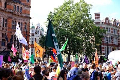 A vibrant street scene showing a protest with bold red and gold banners waving.