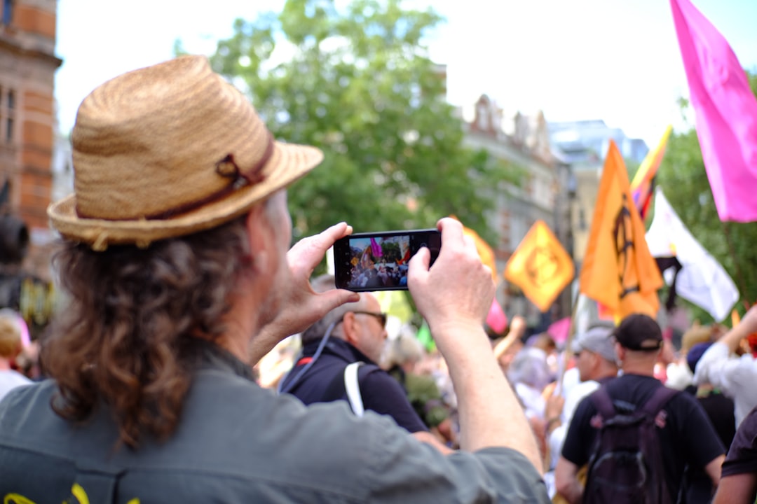 man in brown hat holding black smartphone