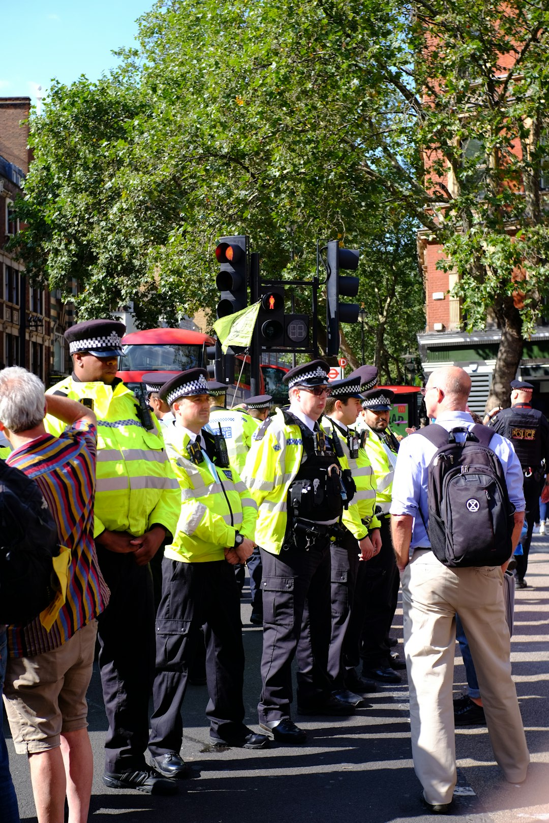 group of people in green safety vest standing on street during daytime