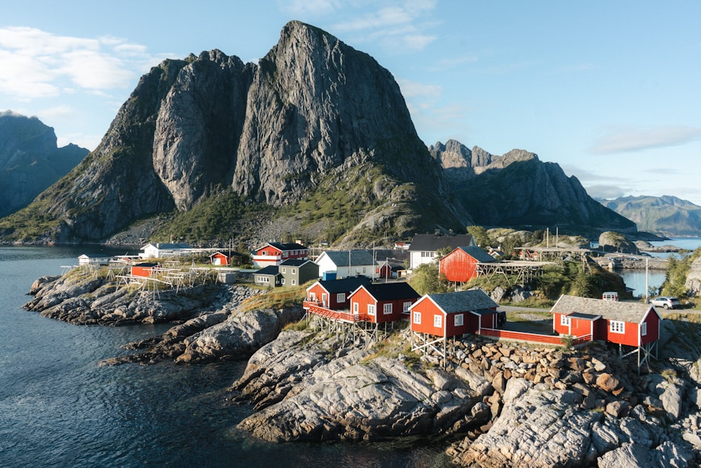 houses near mountain and body of water during daytime