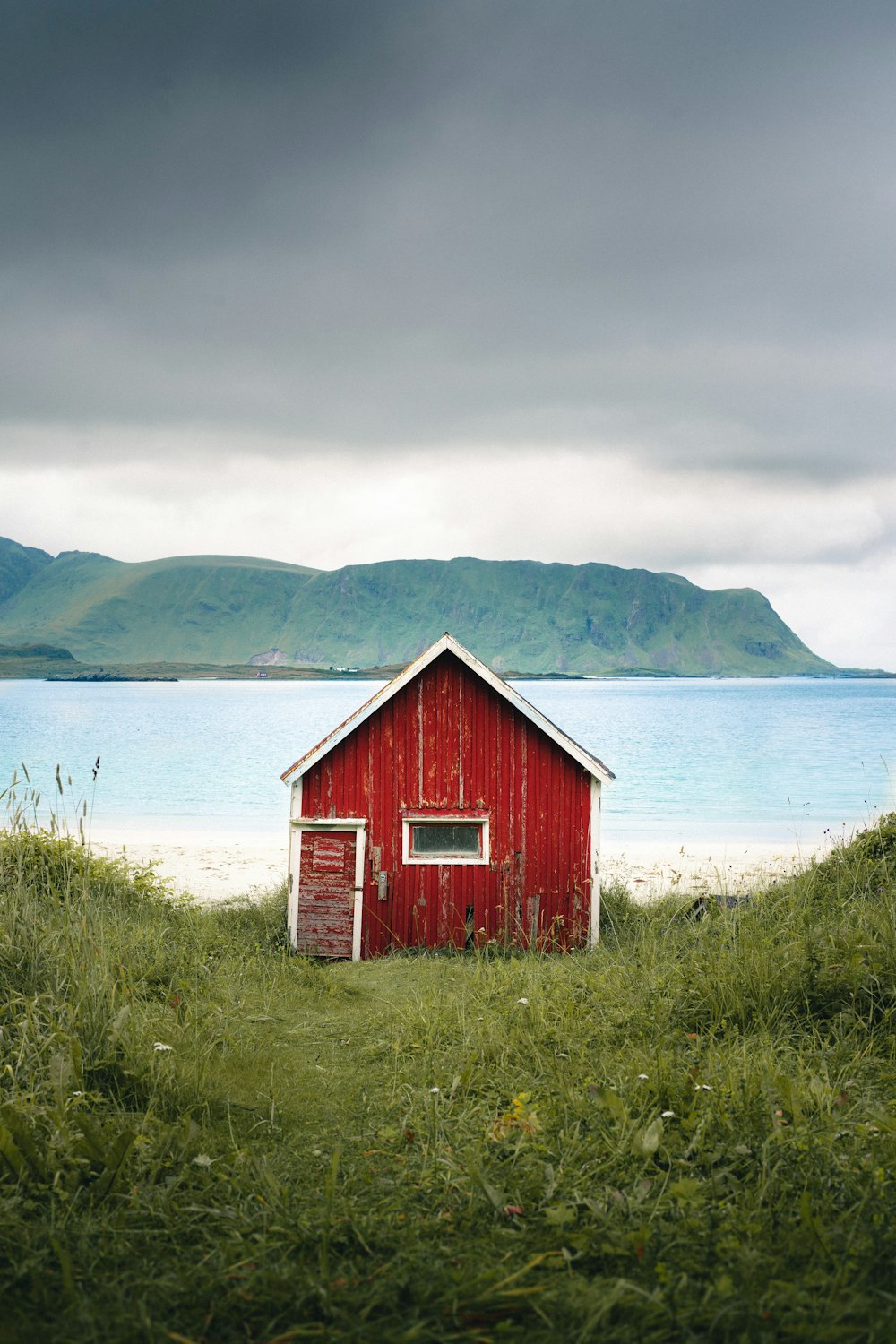 red and white wooden house near body of water during daytime