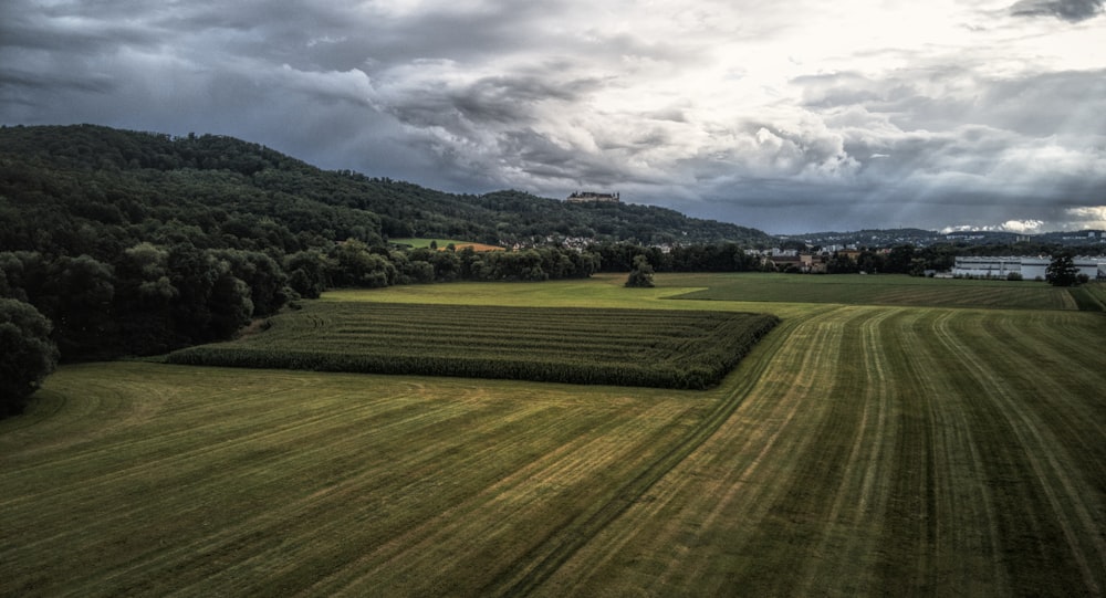 green grass field under cloudy sky during daytime