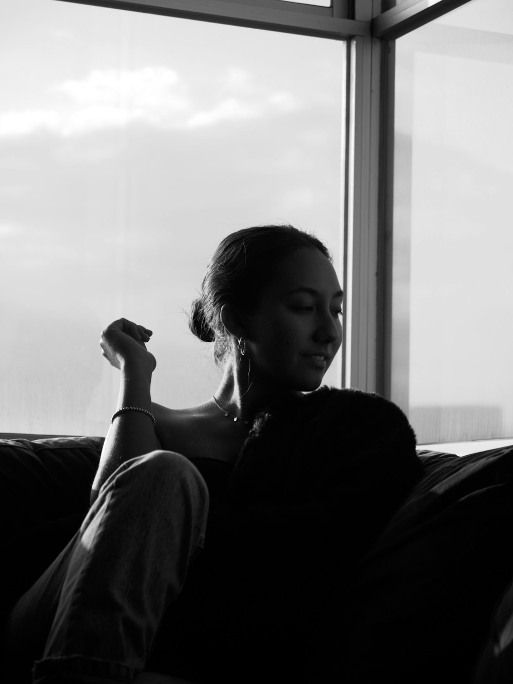 grayscale photo of woman in black shirt sitting on couch